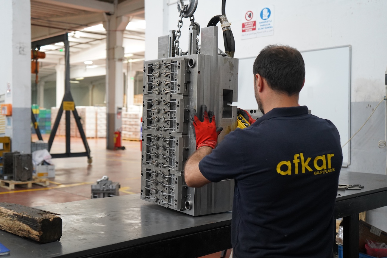 worker preparing plastic pump mold to montage in the machine